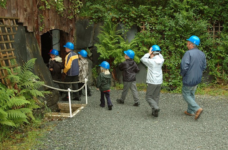 A group on school days out North Wales entering the dark tunnels of the Labyrinth